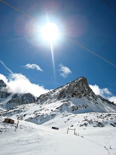 the sun shines brightly over a snowy mountain