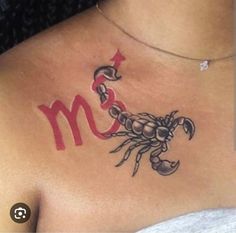 a woman with a scorpion tattoo on her chest and the letter m in red ink