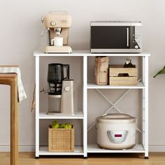 a white shelf with some appliances on top of it and a table next to it