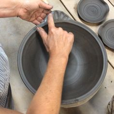 a person is making a bowl out of clay