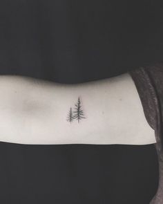 a small pine tree tattoo on the arm