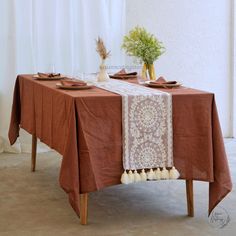 an image of a table setting with place settings and flowers on the table cloths