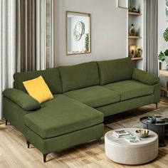 a living room with a large green couch and coffee table in front of the window