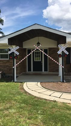 a house decorated for christmas with railroad crossing decorations on the front porch and side door