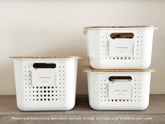 two white storage containers with holes on the lids and handles, one for each container