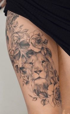 a woman's thigh with a lion and flowers on it