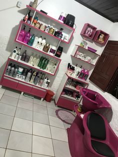 a salon with pink chairs and shelves filled with hair care products on the wall next to a tiled floor