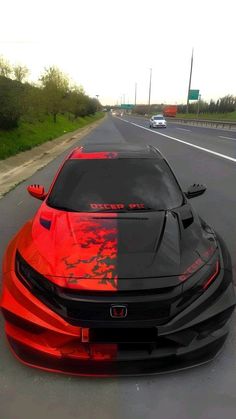 an orange and black sports car on the road