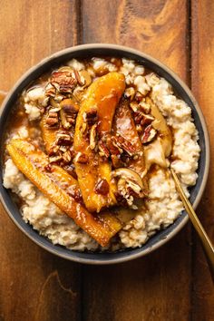 a bowl filled with oatmeal topped with sliced bananas and pecanse