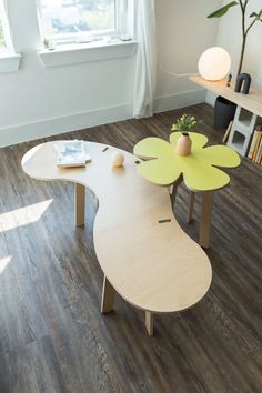 a living room with two tables and a vase filled with flowers on top of them