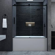 a black and white bathroom with a glass shower door that has two candles on it