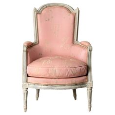 an antique chair with pink upholstered fabric