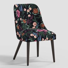 an upholstered chair with floral fabric and wooden legs, in front of a gray background