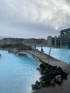 people are swimming in the blue lagoon on a cloudy day