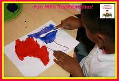 a young boy is painting with red, white and blue paint