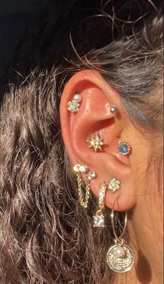 a close up of a person's ear with multiple piercings on it,