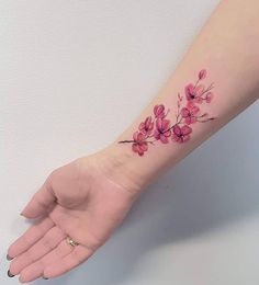 a woman's arm with pink flowers on it