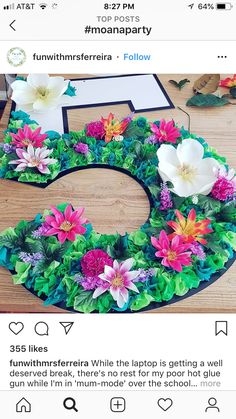 the letter b is made out of flowers and leaves on top of a wooden table