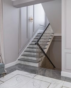 an elegant staircase with marble floors and white walls