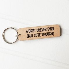 a wooden keychain with the words worst driver ever but cute though printed on it