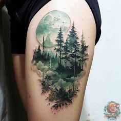 a woman's thigh with a forest scene and moon tattoo on the side of her leg