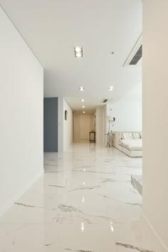 an empty room with white walls and marble flooring in the foreground is a living area