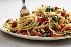 a white plate topped with spaghetti and vegetables