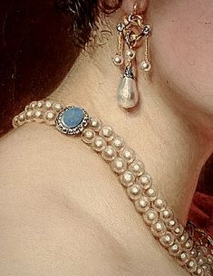 a close up view of a woman's neck with pearls and jewels on it