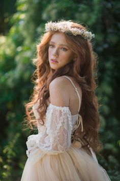 a woman with long red hair wearing a dress and a tiara on her head