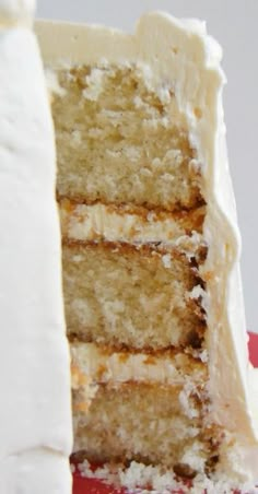 a slice of cake with white frosting on a red plate