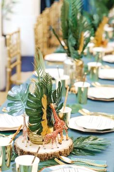 a table set with plates and place settings for an animal themed dinnereon party or baby's first birthday