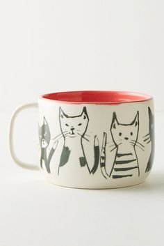 two mugs with black and white cats on them, one has an orange rim