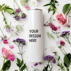 a white coffee cup surrounded by flowers on a white surface with the words your design here