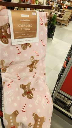 someone is holding up a pink blanket with gingerbreads on it in a store