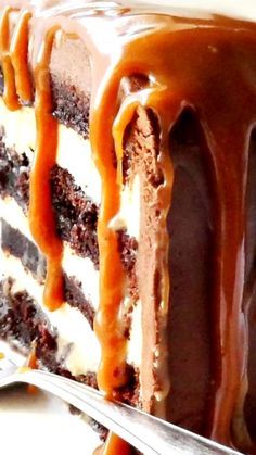 a slice of chocolate cake with caramel drizzle on top and the rest of the cake covered in icing