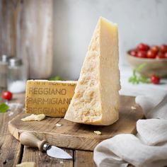 a piece of cheese sitting on top of a wooden cutting board