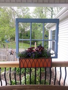 a window box filled with flowers on top of a wooden bench in front of a house