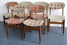 six chairs sitting next to each other in front of a wall with the same pattern on them