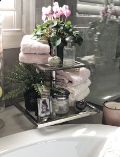 a bathroom sink filled with lots of towels and flowers