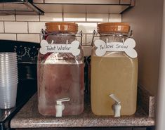 two jars with labels on them are sitting on the kitchen counter next to each other