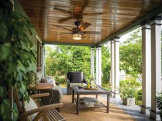 an outdoor covered porch with furniture and plants