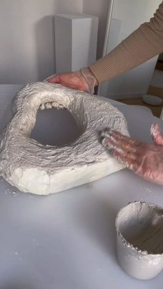 someone is making something out of clay on a table