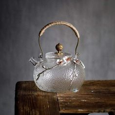 a glass tea pot sitting on top of a wooden table