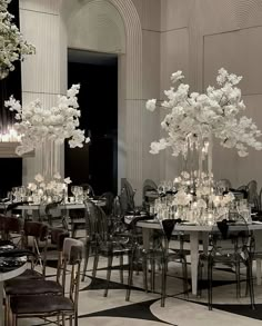 a room filled with tables and chairs covered in white flowers