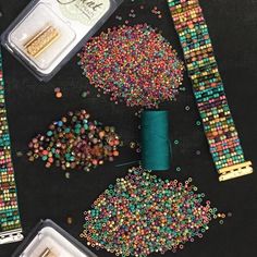 beads, spools and other crafting supplies laid out on a black surface