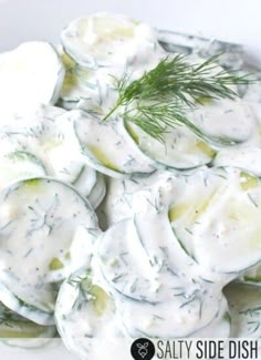 cucumber salad with dill dressing in a white bowl