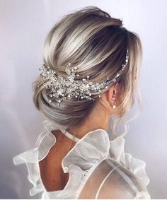 a woman with blonde hair wearing a bridal headpiece made of crystal stones and pearls