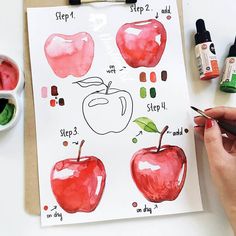 someone is drawing an apple with markers and watercolors on the paper next to them