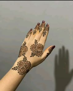 a woman's hand with henna tattoos on it