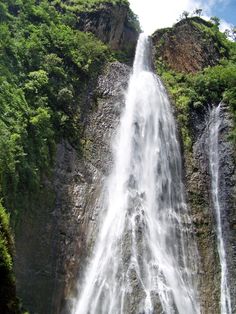 a large waterfall in the middle of a forest